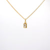 A delicate gold chain necklace with a small rectangular bezel-set clear gemstone pendant, shown against a plain white background.