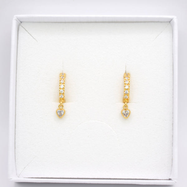 A pair of gold drop earrings with small clear stones, displayed on a white jewelry box against a white background.