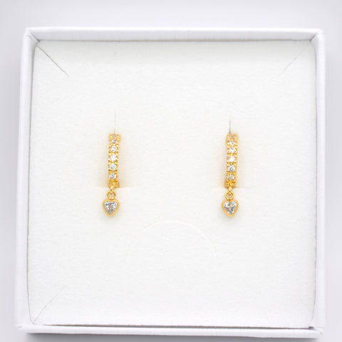 A pair of gold drop earrings with small clear stones, displayed on a white jewelry box against a white background.